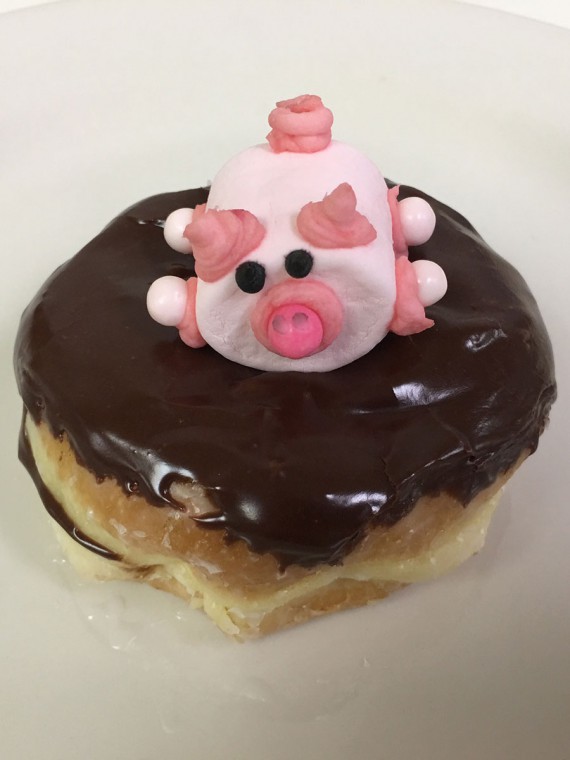 Pig-in-Mud-donut-which-is-a-raised-donut-filled-with-Colorado-Creme-(commonly-known-as-Bavarian-Creme),-chocolate-frosting-and-a-decorated-pink-marshmallow-pig-on-top