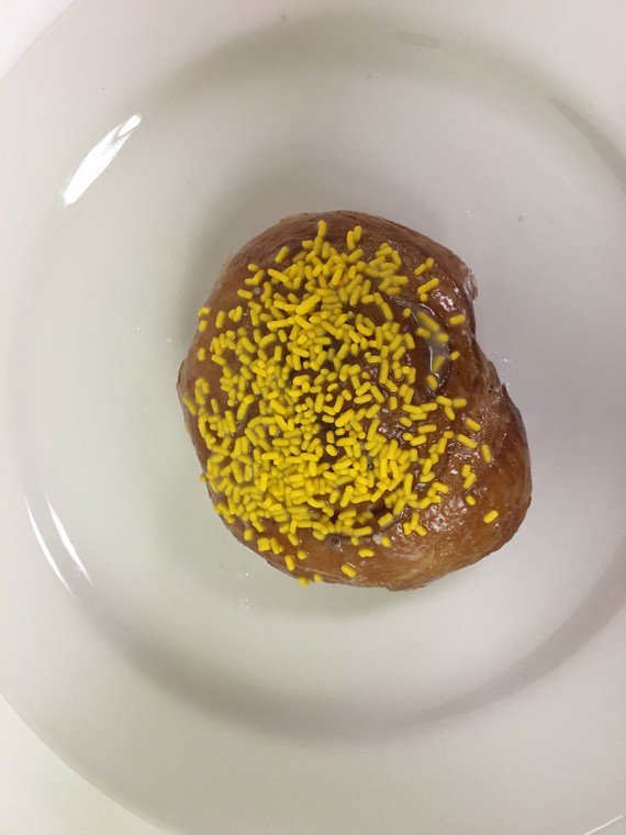 Roll-in-the-Hay-donut.-It-is-a-glazed-cinnamon-roll-with-sprinkles
